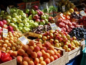 aprictos nectarines plums apples and other fruit at a market stall