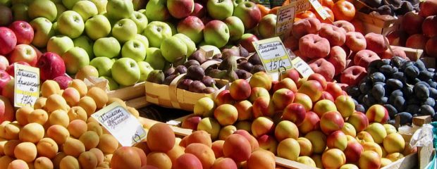 aprictos nectarines plums apples and other fruit at a market stall