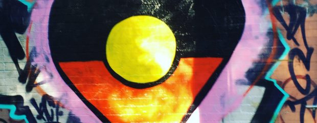 heart shaped Aboriginal flag street art in sun during lockdown in Sydney innerwest