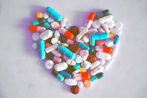 different coloured pills and capsules arranged in a heart shape
