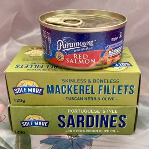 stack of tinned seafood on white background mackeral fillets, sardines, can paramount red salmon