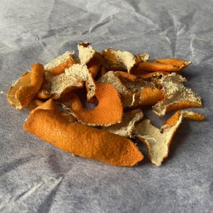 a pile of dried mandarin peel on crumpled white paper