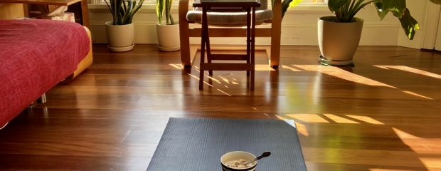 Yoga mat with bowl and spoon in light filled room