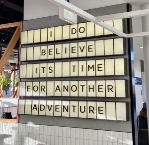 Black letters on a white digital board read "I do believe its time for another adventure