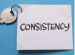 key attached tow white square of paper with consistency written in black texta